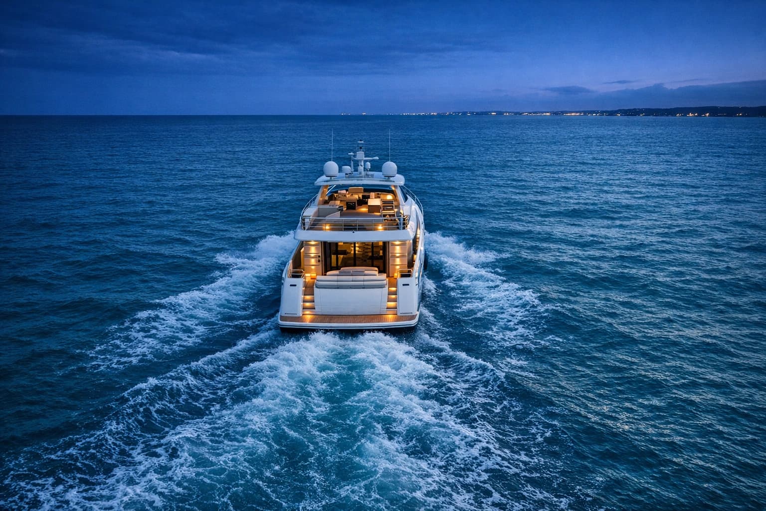 Illustration: an aerial view of a motor yacht underway at blue hour.